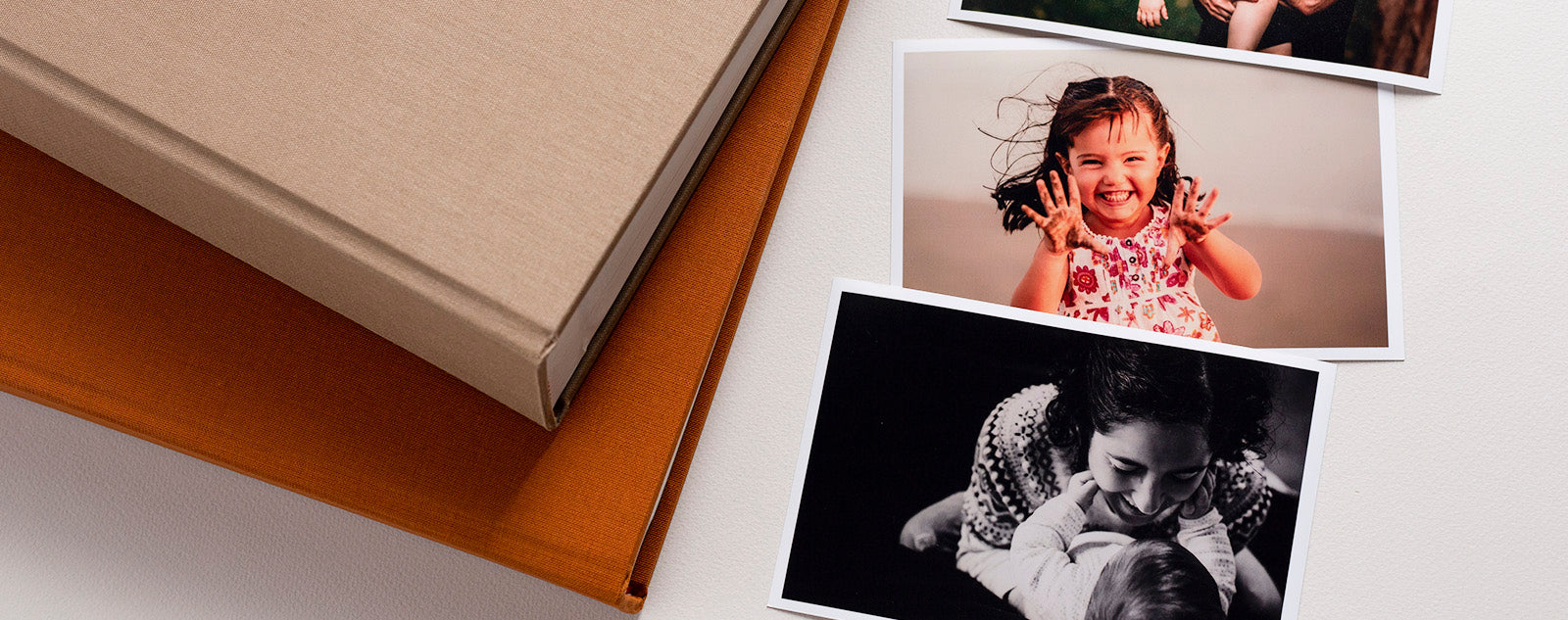 Fotografías impresas al lado de un par de cuadernos.