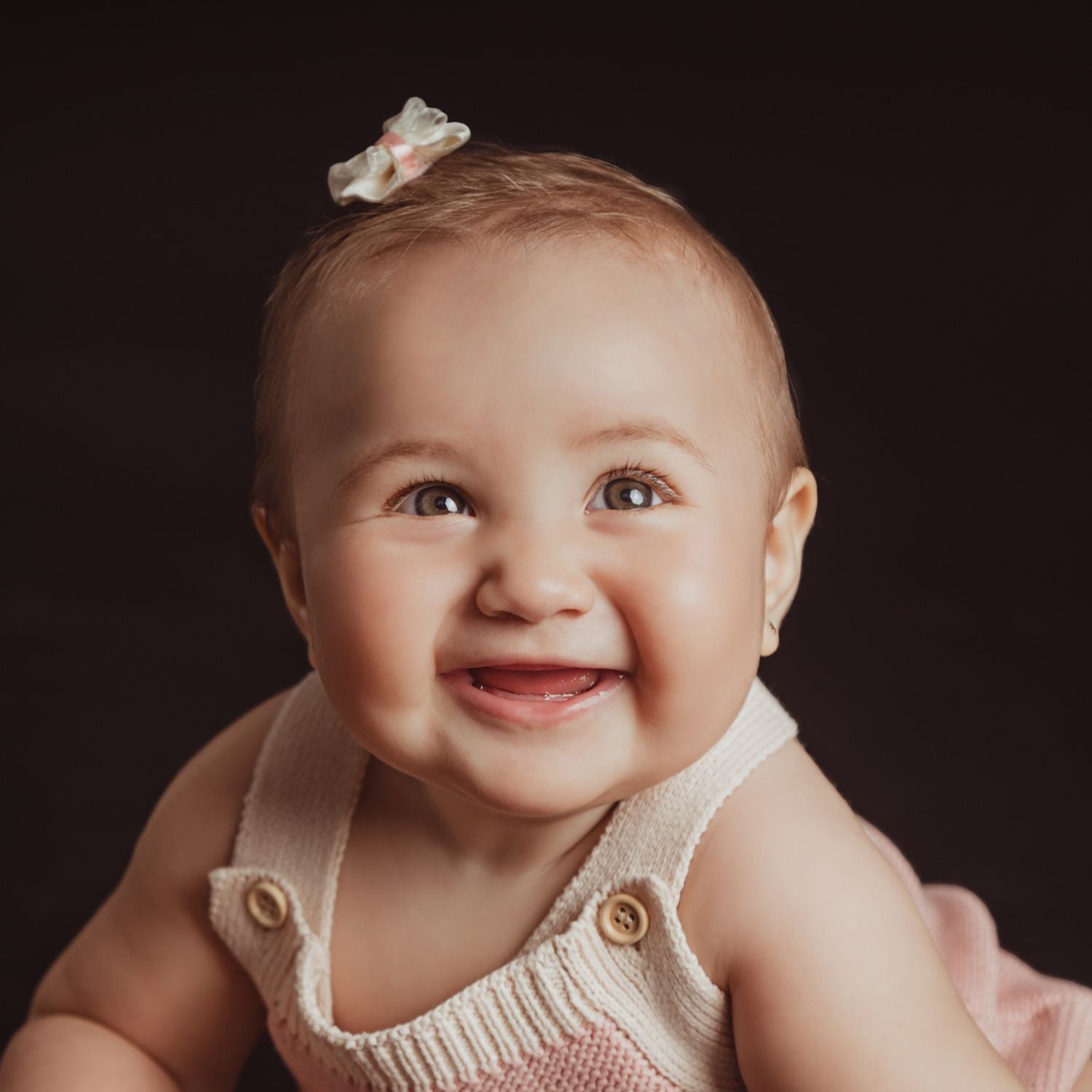 Bebe sonríe a la cámara.