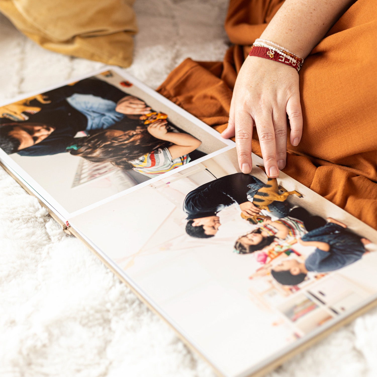 Un álbum de fotos sobre una mesa. Una mano lo revisa. 